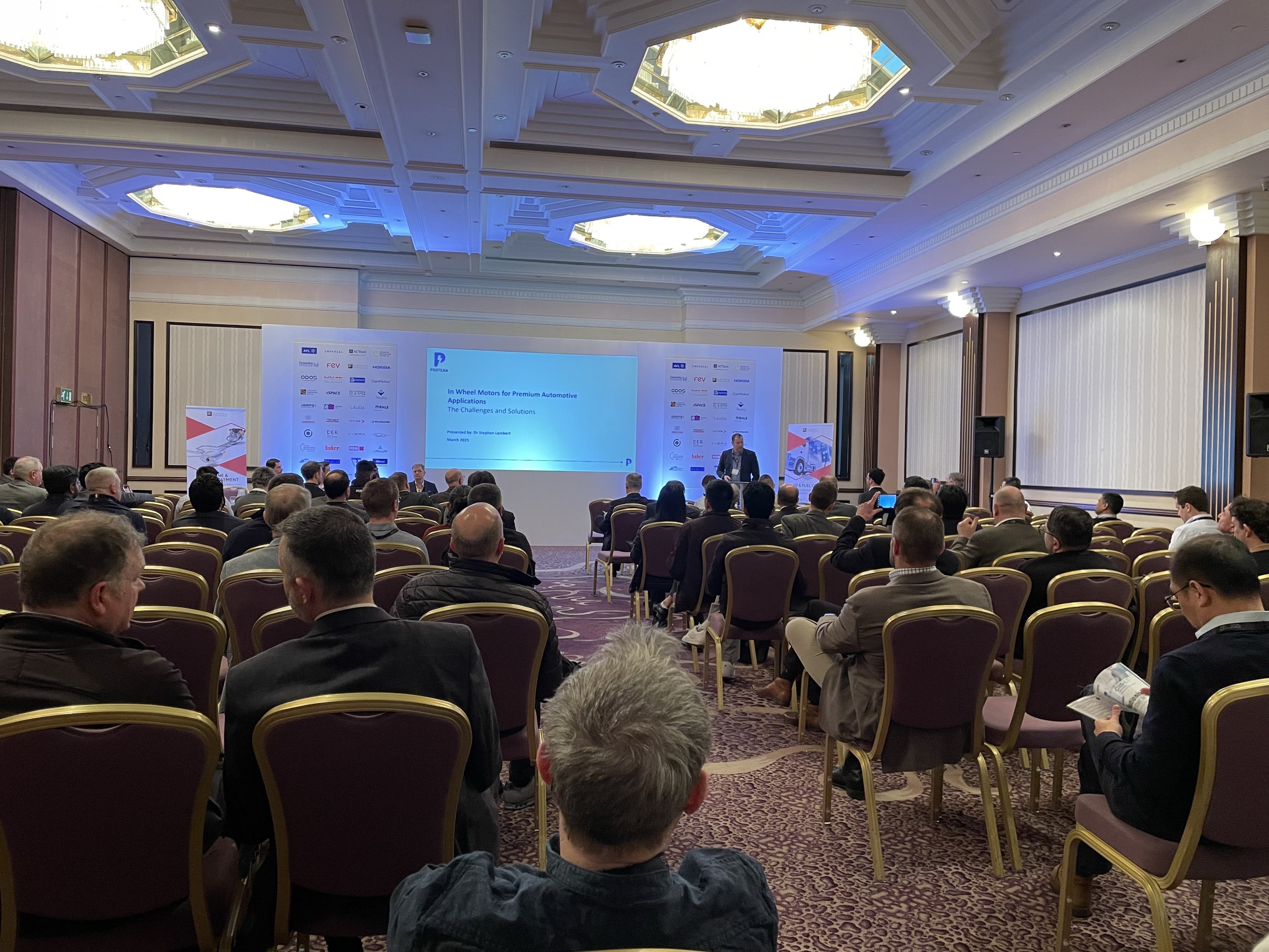 CTO Stephen Lambert stands at the front of a room of seated guests ready to present